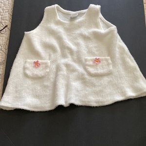 White dress with pink flowers on both pockets.